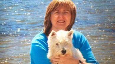 Alison Page, creator of Corrie’s Capers with her westie on the beach.