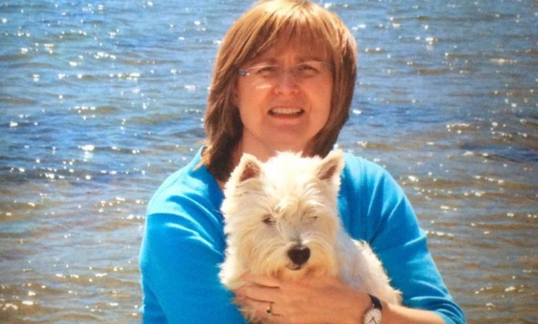 Alison Page, creator of Corrie’s Capers with her westie on the beach.
